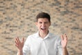 Portrait of aggressive young man against brick wall Royalty Free Stock Photo