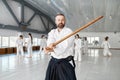 Portrait of aikido sensei master with wooden sword at group training