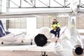 Portrait of an aircraft mechanic in a hangar with jets at the airport - Checking the aircraft for safety and technical function