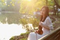 Portrait Aisan Chinese girl woman artist play violin in nature park forest enjoy leisure time performance outdoor lake bench