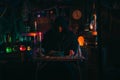 portrait of alchemist magician in interior of dark laboratory workshop with flasks and equipment