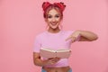 Portrait of alluring young woman with colored hair smiling and holding book