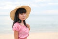 Portrait alone woman standing at coast with hat on blur blue sea and blue sky.