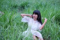 Portrait Alone Woman with white dress sitting on meadow for Rest at park.