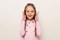 Portrait of amazed astonished little brown haired little girl covered with stickers posing isolated over white background showing Royalty Free Stock Photo