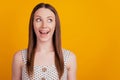 Portrait of amazed crazy lady look side empty space open mouth on yellow background