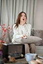 Portrait, Amazed and excited young Asian woman on the sofa watching a TV shows or Sci-fi movie Royalty Free Stock Photo