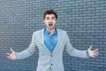 Portrait of amazed handsome bearded man in casual style standing and looking at camera with raised arms and surprised face Royalty Free Stock Photo