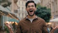 Portrait amazed shocked Indian Arabian ethnic male student man guy businessman open mouth victory celebrating shouting