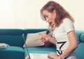 Portrait of an amazed surprised woman with laptop sitting on a couch Royalty Free Stock Photo