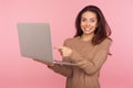 Portrait of amazed woman pointing at laptop and looking at camera with shocked expression, pleasantly surprised Royalty Free Stock Photo