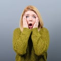 Portrait of a amazed woman with spread hands against gray background Royalty Free Stock Photo