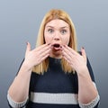 Portrait of a amazed woman with spread hands against gray background Royalty Free Stock Photo