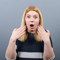 Portrait of a amazed woman with spread hands against gray background Royalty Free Stock Photo