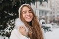 Portrait amazing joyful girl with long brunette hair in snow enjoying winter time on street. Brightful emotions, great