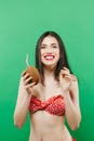 Portrait of Amazing Smiling Brunette in Bright Swimwear Posing with Cocktail in Studio on Green Background. Royalty Free Stock Photo