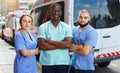 Portrait of ambulance team of three standing near ambulance car Royalty Free Stock Photo