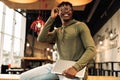 Portrait of an American African man with a laptop in his hands, sitting at the desk in the office, in the classroom Royalty Free Stock Photo