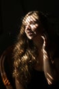 Portrait of american european woman sitting in chair, striped shadows.