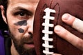 Portrait of american football player holding a ball and looking at camera Royalty Free Stock Photo