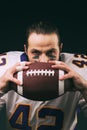 Portrait of american football player holding a ball and looking at camera Royalty Free Stock Photo