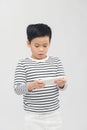 Portrait of an amused cute little kid playing games on smartphone isolated over white background