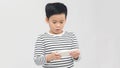 Portrait of an amused cute little kid playing games on smartphone isolated over white background