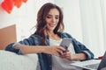 Portrait of amused girl using a mobile phone