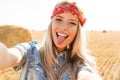 Portrait of amusing girl 20s laughing and taking selfie while wa Royalty Free Stock Photo