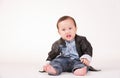 Portrait angry action of baby boy in leather jacket, white back