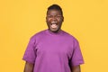 Portrait of angry african man in purple t-shirt shouting loudly Royalty Free Stock Photo