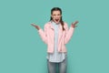 Angry aggressive teenager girl wearing pink jacket standing with raised arms, screaming with hate. Royalty Free Stock Photo