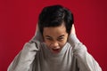 Portrait of angry Asian boy screaming loud while covering his ears, naughty rebel school student concept Royalty Free Stock Photo