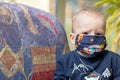 Portrait of angry baby with reusable protective face mask Royalty Free Stock Photo