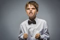 Portrait of angry boy isolated on gray background. Negative human emotion, facial expression. Closeup Royalty Free Stock Photo