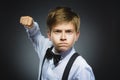 Portrait of angry boy isolated on gray background. He raised his fist to strike. Closeup Royalty Free Stock Photo