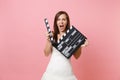 Portrait of angry bride woman in wedding dress screaming holding classic black film making clapperboard on