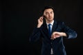 Portrait of angry business man wearing blue business suit and tie talking on the phone, looking his watch Royalty Free Stock Photo