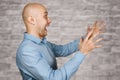 Portrait angry dangerous bald man trying to watch and scare on white brick wall background