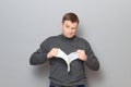 Portrait of angry furious blond mature man tearing paper sheet