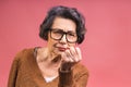 Portrait of angry grey haired old strict senior woman wearing glasses pointing up threatening with finger. Grandmother isolated