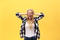 Portrait of an angry irritated woman with hands raised shouting at camera isolated on yellow background Royalty Free Stock Photo