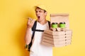 Portrait of angry man courier with thermo backpack in white T-shirt and cap, recording voice message to client, frowning face,