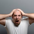 Portrait of a angry man screaming against gray background Royalty Free Stock Photo