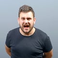 Portrait of a angry man screaming against gray background Royalty Free Stock Photo