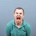 Portrait of a angry man screaming against gray background Royalty Free Stock Photo