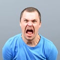 Portrait of a angry man screaming against gray background Royalty Free Stock Photo