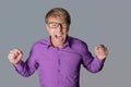 Portrait of a angry man with glasses staring at camera, shows finger and shouting over gray background Royalty Free Stock Photo