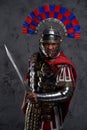 Violent legionnaire wielding gladius screaming against dark background