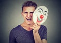 Portrait angry screaming man taking off a clown mask expressing happiness Royalty Free Stock Photo